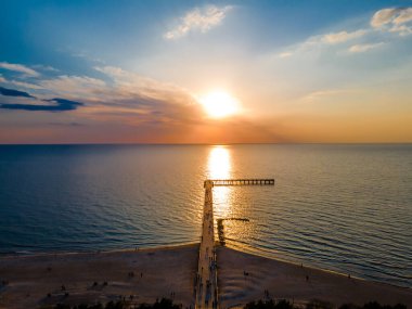 Palanga Köprüsü 'nün havadan görünüşü Baltık Denizi' ne doğru düz bir yol ve günbatımı