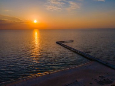 Baltık Denizi 'ne giden Palanga köprüsünün havadan görünüşü ve ufukta gün batımı 