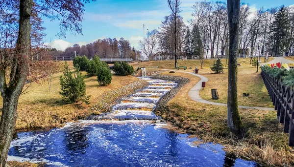 Ein künstlicher Wasserfall und ein Bach in einer kleinen Stadt in Litauen — Stockfoto