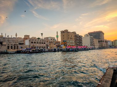 11 23 2025 Dubai, Birleşik Arap Emirlikleri. Dubai deresi ve Deira Old Souk feribotu. Dubai Deresi 'nden geçen gemilerin nakliye ve seyrüsefer