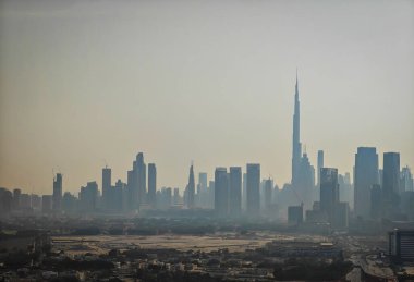 Dubai Şehir Merkezi ve uzaktaki Business Bay. Dubai 'nin alacakaranlıktaki hava aracı görüntüsü ve kum fırtınası tozu