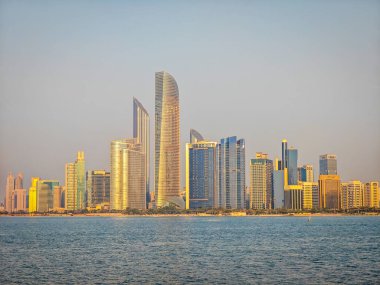 Abu Dabi gökdeleninin manzarası Abu Dabi marina tarafından gün batımında yükseliyor.