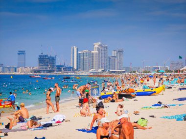 1203 2025 - Dubai, Birleşik Arap Emirlikleri. Güneşli bir günde Dubai JBR Plajı. İnsanlar kum, deniz ve açık gökyüzünün tadını çıkarıyor. Dubai tatil geçmişi