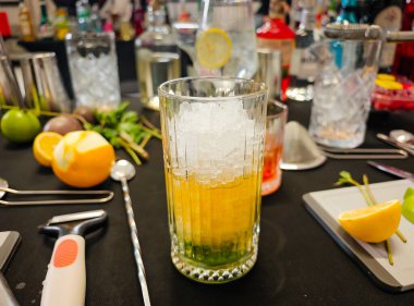 Karışım - profesyonel kokteyl sahnesi otlar, narenciyeler, bar malzemeleri, bardaklar ve içkilerle. Kokteyl hazırlama için mikoloji çalışma alanı