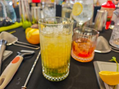 Karışım - profesyonel kokteyl sahnesi otlar, narenciyeler, bar malzemeleri, bardaklar ve içkilerle. Kokteyl hazırlama için mikoloji çalışma alanı