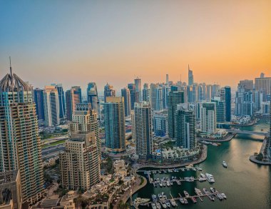 12: 30 2025 Dubai, BAE. Gün batımında Dubai Marina 'nın havadan görüntüsü. Dubai ufuk çizgisinin insansız hava aracı görüntüsü, şehir kıyısı. Dubai panoramik arkaplanı