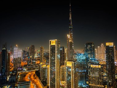 01 11 2026, Dubai, BAE. Dubai Business Bay siluetinin gece hava görüntüsü, insansız hava aracı fotoğrafçılığı aydınlanmış gökdelenleri ve modern şehir manzaralarını yakalıyor.