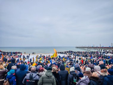 02 07 2026 - Palanga, Litvanya. Birçok kış yüzücüsü plajda büyük bir kamp ateşi etrafında toplanır ve dondurucu soğuk deniz suyunda yüzmeye hazırdır. Sağlıklı yaşam tarzı insan geçmişi