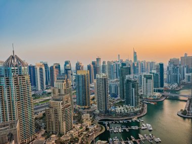 12: 30 2025 Dubai, BAE. Gün batımında Dubai Marina 'nın havadan görüntüsü. Dubai ufuk çizgisinin insansız hava aracı görüntüsü, şehir kıyısı. Dubai panoramik arkaplanı