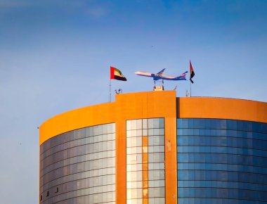Dubai, Birleşik Arap Emirlikleri 'ndeki hükümet binasının üzerinde uçan büyük bir ticari uçak. Abu Dabi yakınlarında bir Rus uçağı.