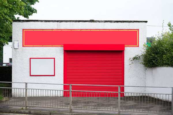 Shop front with blank sign and closed shutter door