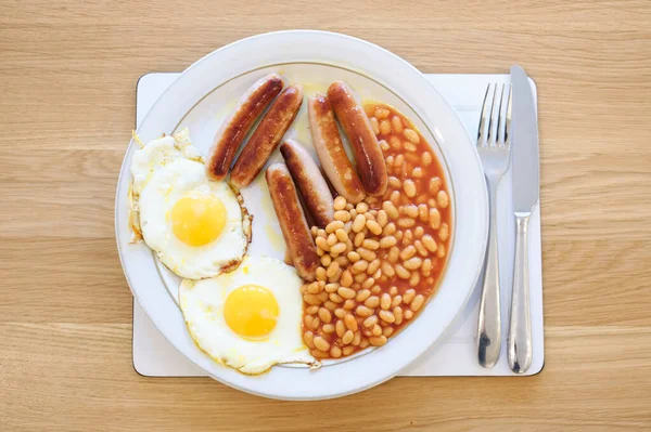 Смажений сніданок з квасолею та яйцями на тарілці — стокове фото