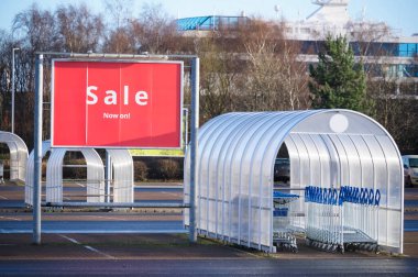 Alışveriş merkezinin yanındaki otoparkta indirimli kırmızı pankart.