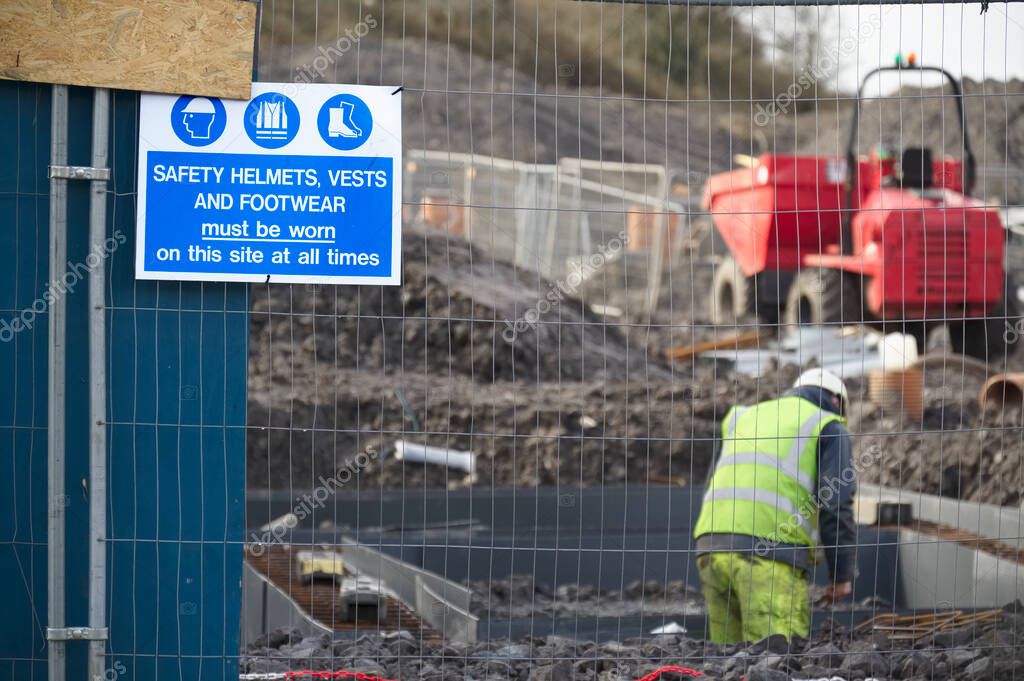 Construction site health and safety message rules sign board signage on fence boundary uk