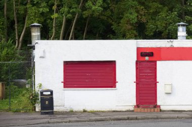 Dükkanın önünde boş tabela ve kapalı kapılar var.