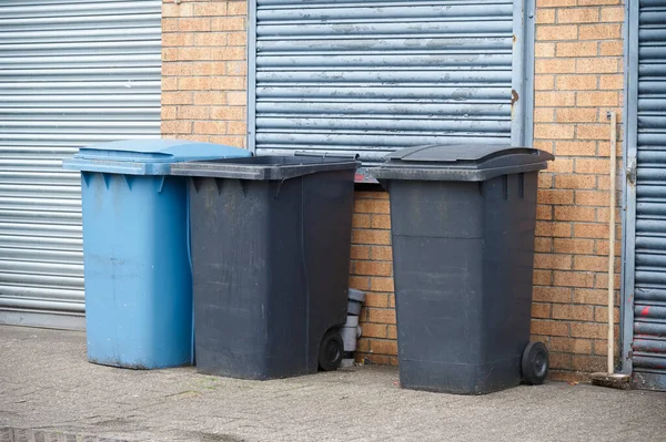 Wheelie bins blue and black for refuge collection in row