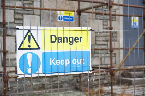 Construction site health and safety message rules sign board signage on fence boundary