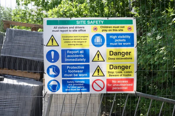 Construction site health and safety message rules sign board signage on fence boundary