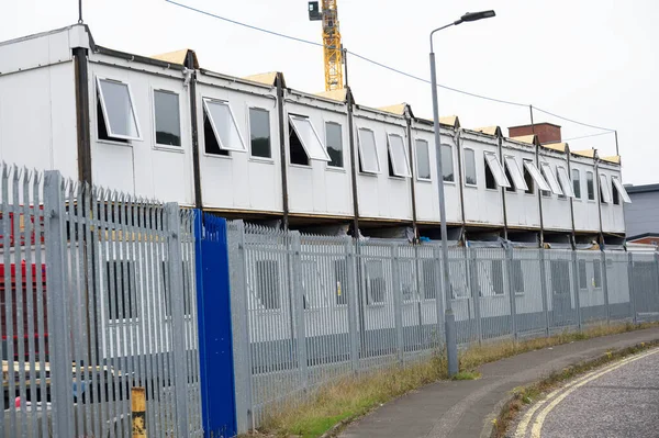 Construction site office cabin in a row with open windows