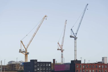 Tower cranes high in sky at construction site UK