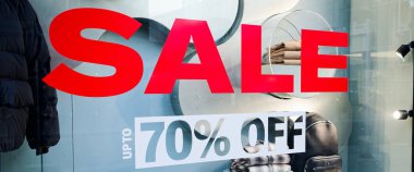 Ana cadde vitrininde indirim tabelası.