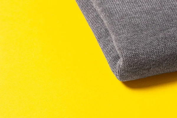 Gray wool fabric on a sunny yellow background. The perfect background color for 2021. The trend of the spring-summer season. Space for text, empty, copy space.