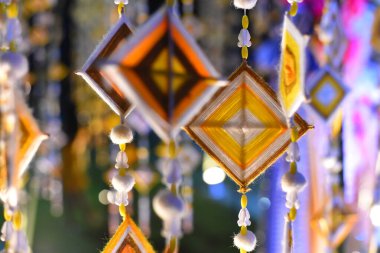 Dekorasyon ve yaz boyunca Tayland kültür festivalini kutlamak için bambu direğinden asılı el yapımı altıgen örgü bayrakları. Renkli kumaş, geleneksel Budist inanışlarıyla şişirilmiş. Tayland, Myanmar, Laos 'ta.