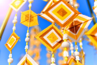 Dekorasyon ve yaz boyunca Tayland kültür festivalini kutlamak için bambu direğinden asılı el yapımı altıgen örgü bayrakları. Renkli kumaş, geleneksel Budist inanışlarıyla şişirilmiş. Tayland, Myanmar, Laos 'ta.