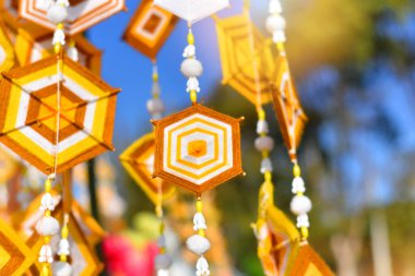 Dekorasyon ve yaz boyunca Tayland kültür festivalini kutlamak için bambu direğinden asılı el yapımı altıgen örgü bayrakları. Renkli kumaş, geleneksel Budist inanışlarıyla şişirilmiş. Tayland, Myanmar, Laos 'ta.