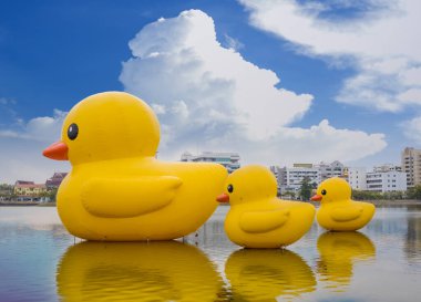 Udon Thani, Tayland - 30 Ocak 2021: Güzel gökyüzüne sahip Tayland 'ın Udon ili gölünde yüzen üç dev sarı lastik ördek.