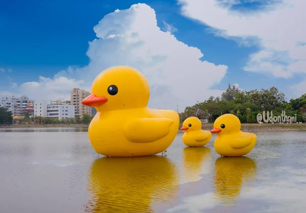 Udon Thani, Tayland - 30 Ocak 2021: Güzel gökyüzü ile Tayland 'ın Udon ili gölünde yüzen üç dev sarı lastik ördek.