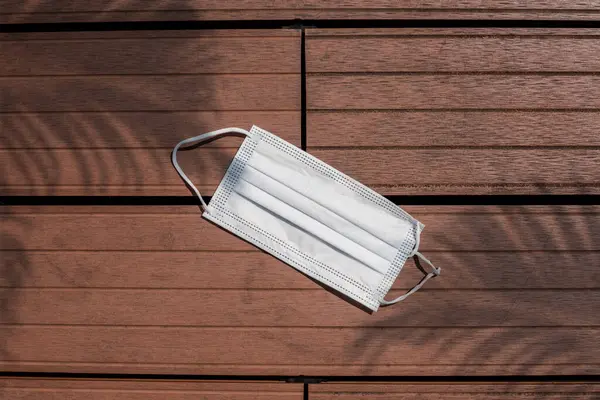 Tek kullanımlık yüz maskesi, maske Ahşap arka planda tıbbi kalkan
