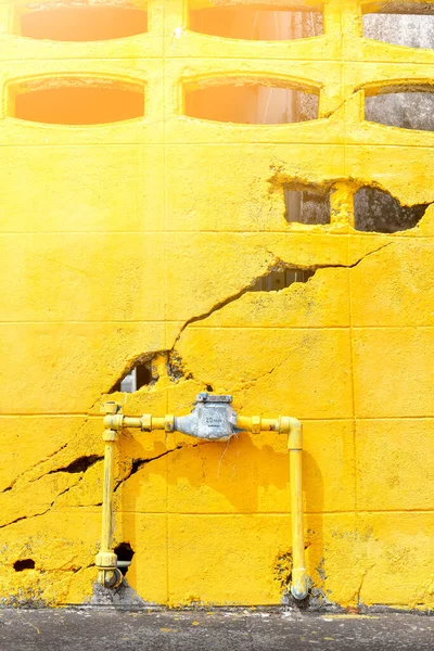 Water meter outside the house, Cracked yellow wall background. Measuring device, Open cover of water meter to check counter number of water consumption, water pipe and meter with waterspout of home. portrait size.