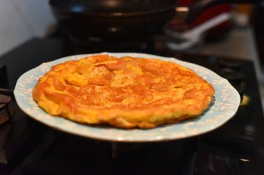 Tipik bir omletle tabağın yakın çekimi. Görüntü gürültülü, odaklanma yumuşak..