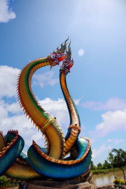 Udon Thani, Thailand - 21 June 2021 : Low angle view of Twin Stucco painted as a large serpent with beautiful sky at Pra kai keaw-wang nakin, Located at Ban Don swan, Phen District, Udon Thani, Thailand