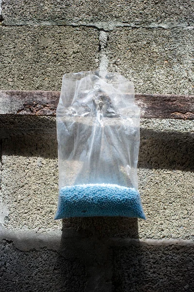 Mavi Kimyasal Gübre plastik poşette duvarda asılı duruyor. Bitkiler için N-P-K gübresi.