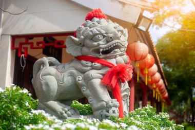 Udon Thani, Tayland - 10 Temmuz 2020: Tayland 'ın Udon bölgesindeki Tayland-Çin Kültür Merkezi' nde kırmızı eşarplı yakın plan taş Çin aslanı