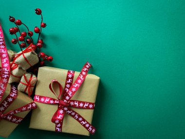 Düz konsept. Yeşil arka planda Noel hediyeleri vardı. Boşluğu kopyala.