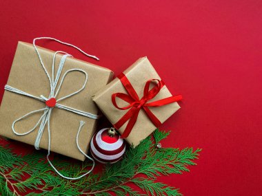 Kırmızı arka planda Noel süsleriyle izole edilmiş Noel hediyeleri. Düz yatıyordu. Boşluğu kopyala.