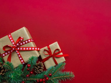 Noel kompozisyonu. Şişmanlar Noel 'de, Yeni Yıl' da, tatil kutlamalarında, kırmızı arka planda fotokopi çekilirken. Şablon, hediye, köknar dalları, kozalaklar ve böğürtlenlerle tasarlandı..