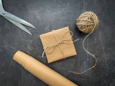 Kırsal Noel hediyesi çalışma alanını kağıt, sicim ve makasla kaplıyor..