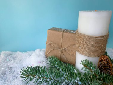 El yapımı Noel süslemeleri. Tatil hediyesi ve beyaz mum. Kış kar arka planı.  