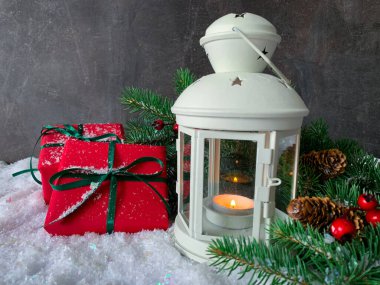 Koyu kırsal ahşap arka planda paketlenmiş Noel hediyeleri. Kış feneri çam kozalakları ve köknar dalları..