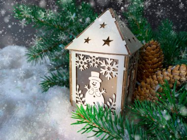 Çam ağacı dallı bir kardan adam olan beyaz oyuncak ahşap bir ev. Noel kar festivali arka planı.