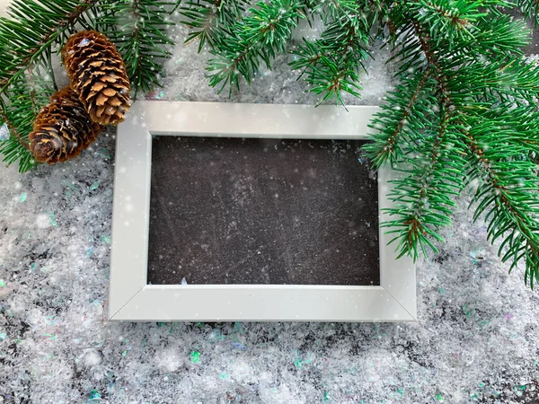 Christmas photo frame template. Holiday mock up with Christmas tree branches. Snowy holiday background.