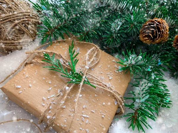 エコ包装材料のギフトボックス クリスマスを無駄にするな 持続可能な休日プレゼント クラフト紙 ツイン トウヒ 松のコーン 冬の雪の背景 — ストック写真