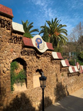 Gaudi mozaik tabelasıyla Park Guell 'in taş duvarının dışında..