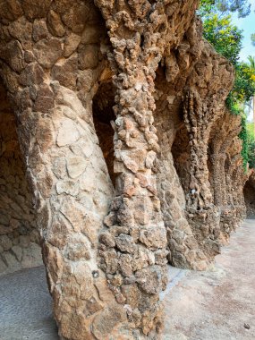 Barselona, İspanya, 12 Mart 2020 - Antoni Gaudi tarafından tasarlanan ünlü Park Guell 'de taş sütunlu kaya geçidi.