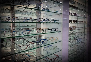 Modern bir gözlük mağazasında gözlüklü durun..