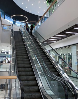 Alışveriş merkezinin içinde modern mimarisi ve soyut iç tasarımı olan yürüyen merdivenler.